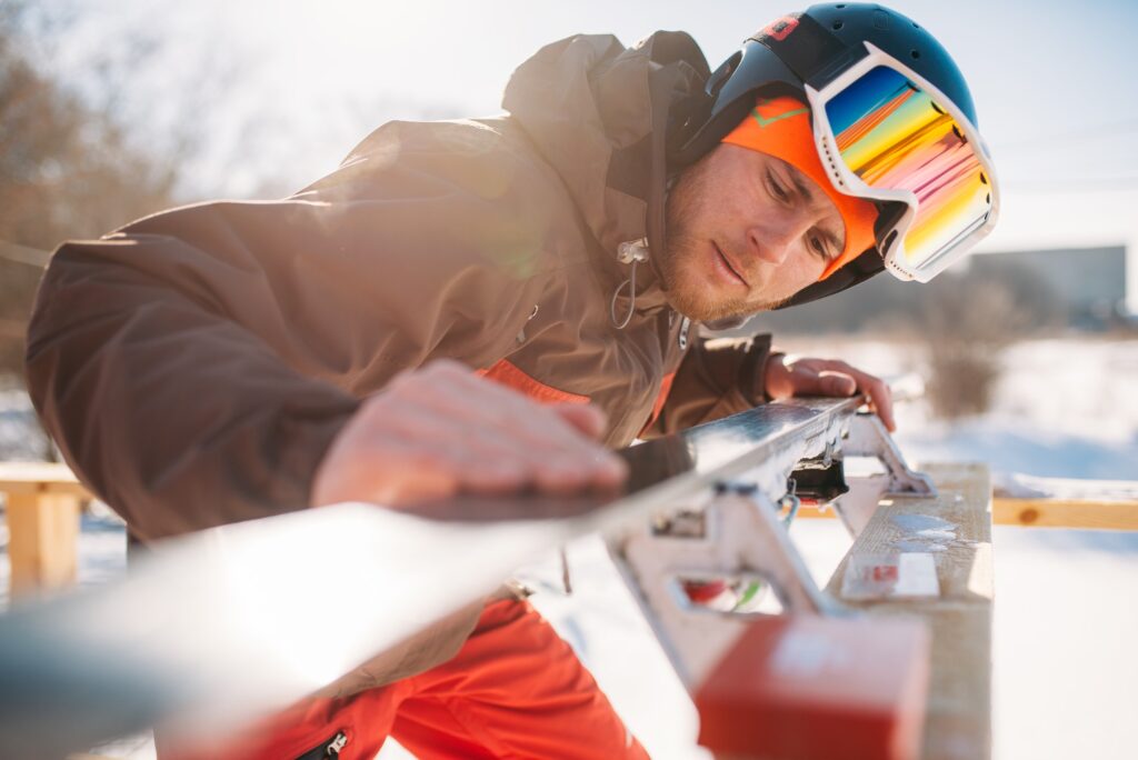 Male skier checks skis before skiing, winter sport