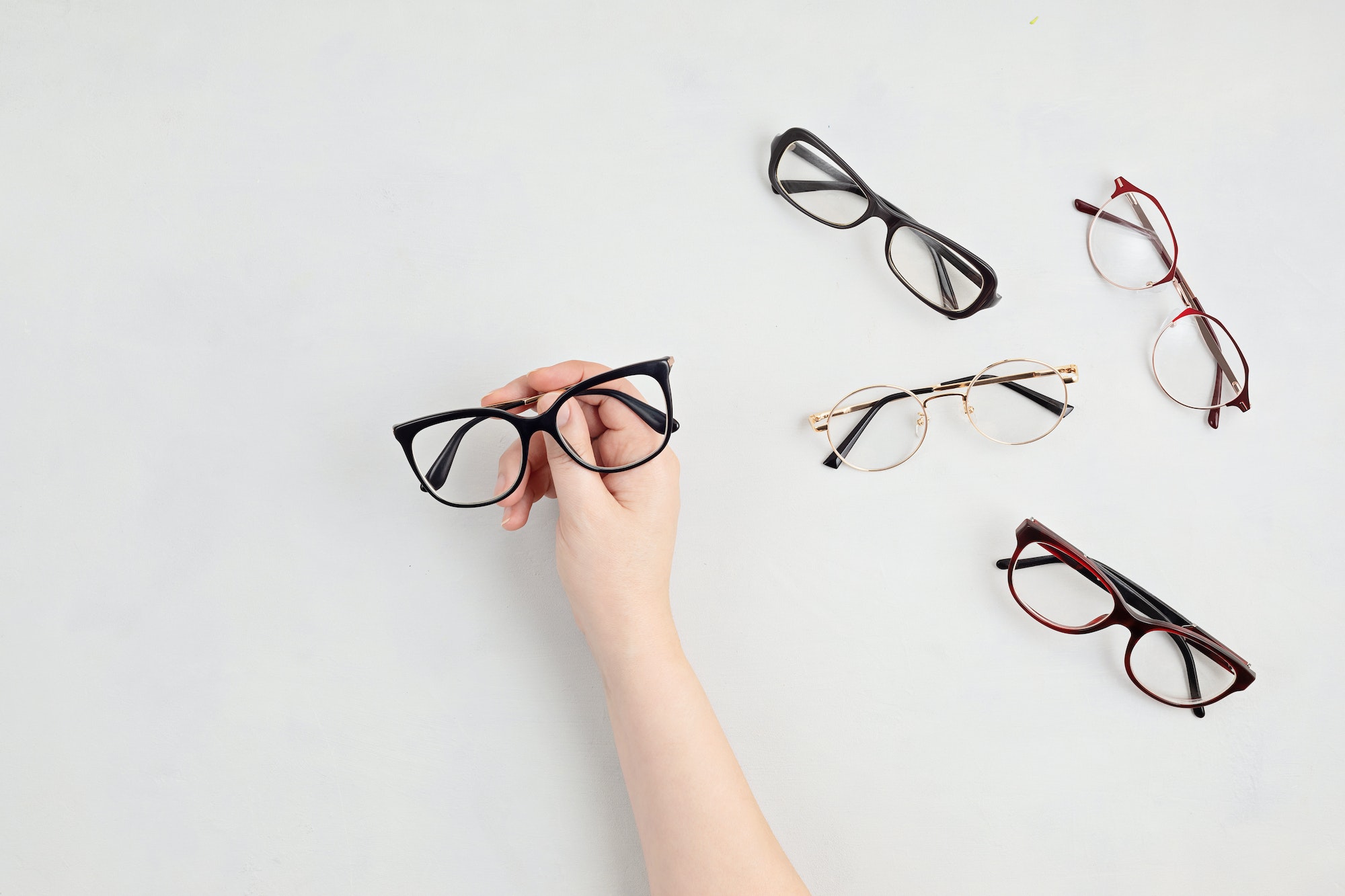 Woman hand holding eyeglasses. Optical store, glasses selection, eye test, vision examination at
